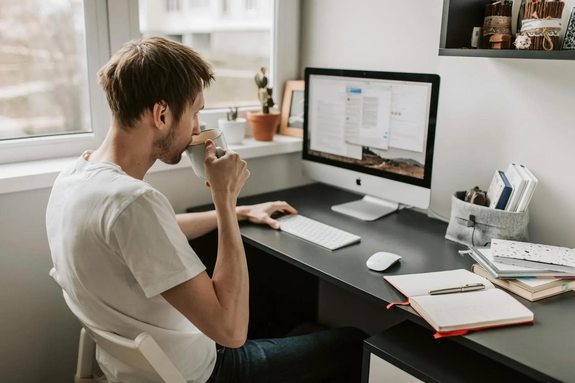 Man at desk drinking coffee